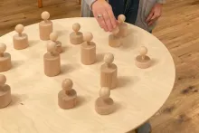 Figuren aus Holz werden auf einer Platte gestellt